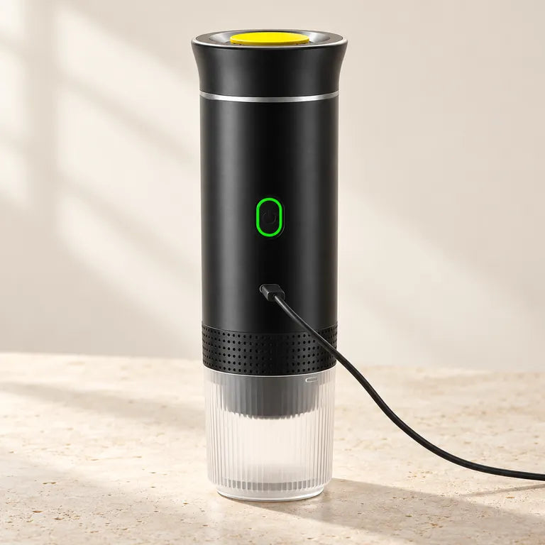 Morrow Cup espresso maker with its yellow lid and a USB-C charging cable connected